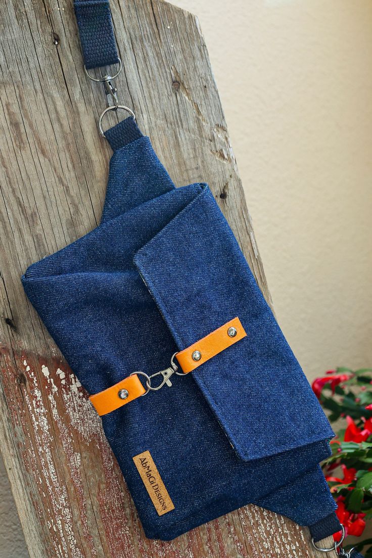 a blue bag hanging on a wooden wall with a chain attached to it and a flower pot in the background