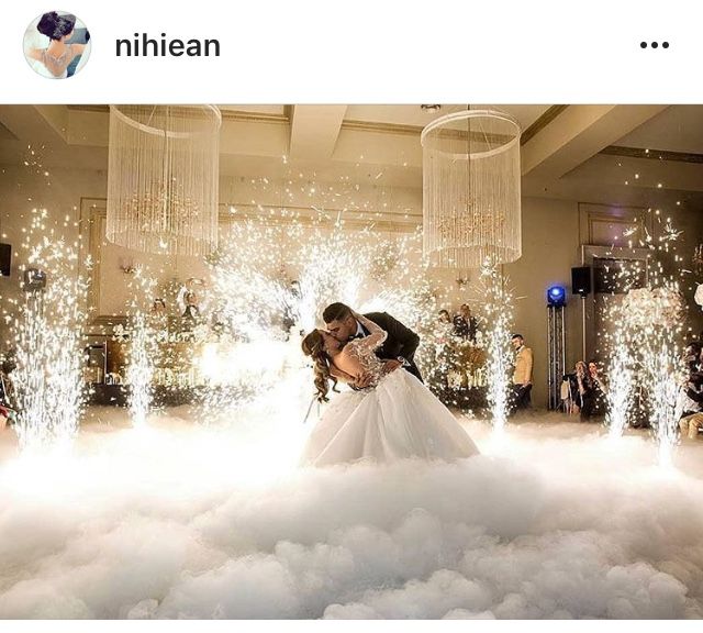 a bride and groom are kissing in the clouds at their wedding reception, surrounded by chandeliers