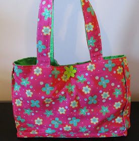 a pink bag with flowers on it sitting on a table