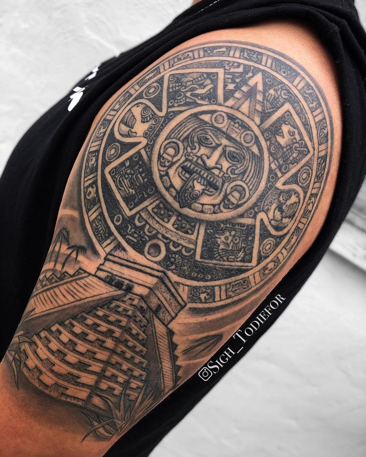 a man with a tattoo on his arm that has an image of a sundial