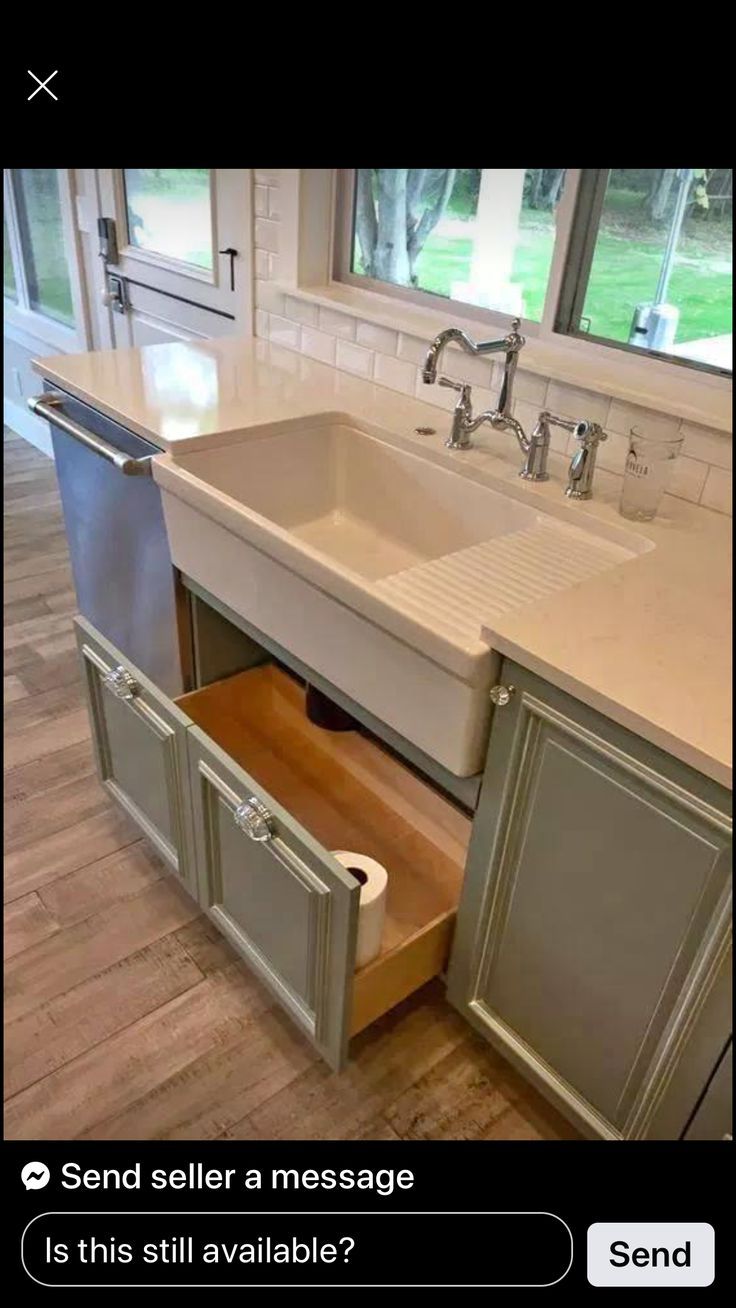 a kitchen sink with an open drawer in the middle and a window to the side