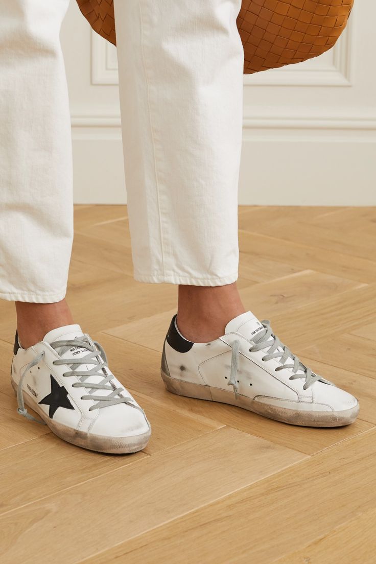 EXCLUSIVE AT NET-A-PORTER. To create their lived-in look, Golden Goose's 'Superstar' sneakers are distressed by hand using patented brushing and waxing techniques. Made from supple white leather, they have contrasting logo-embossed heel tabs and signature star appliqués. Wear yours with everything from cropped jeans to midi skirts.  Shown here with: [Burberry Sweater id1177939], [Co Jacket id1204764], [Goldsign Jeans id1204876], [Bottega Veneta Tote id1206755], [Bottega Veneta Earrings id120656… Superstar Outfit, Golden Goose Sneakers Outfit, Golden Goose Outfit, Burberry Sweater, Golden Goose Sneakers, Golden Goose Shoes, Golden Goose Deluxe Brand, Sneakers Outfit, Distressed Leather