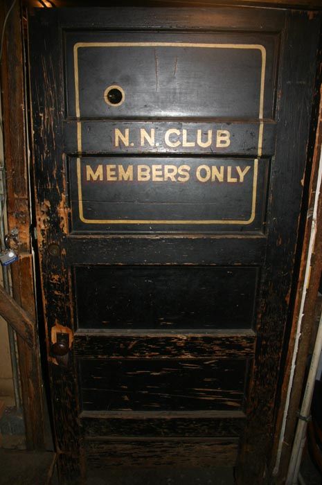 an old door with a sign on it that says n n club members only inside