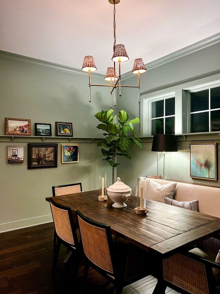 a dining room table with four chairs and a potted plant on top of it