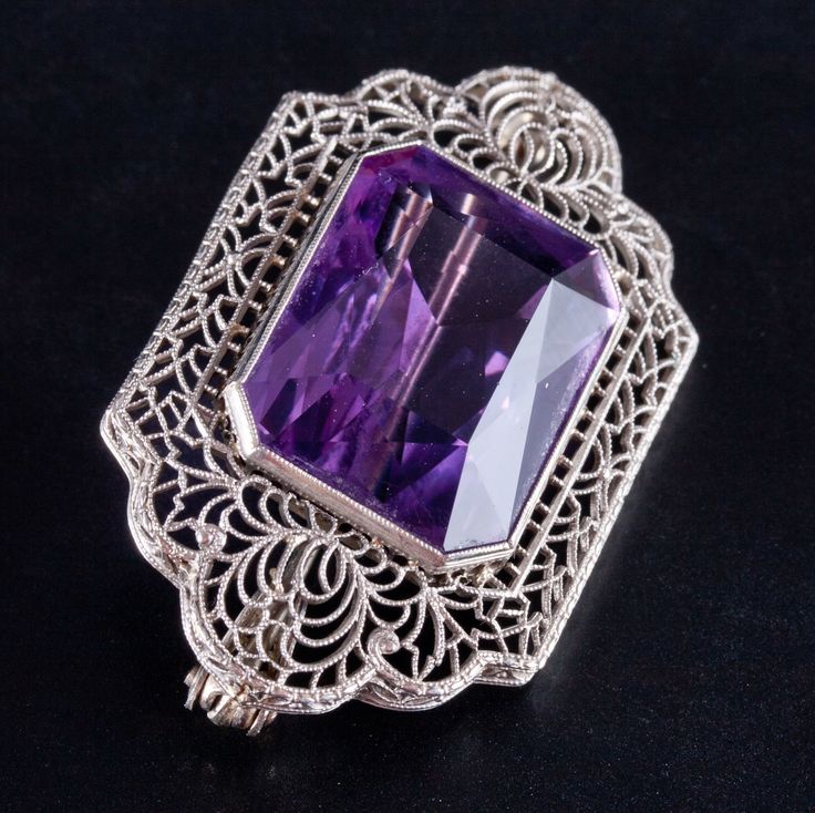 Vintage 1920's 14k White Gold Amethyst Solitaire Brooch Pendant Combo 17.25ctWorn on hats, jacket lapels or on the hip and with sleeveless outfits, this vintage 1920's 14k white gold amethyst brooch added color and class to any outfit back then. With a beautifully cut amethyst and fine filigree surrounding the stone, this brooch is a truly stunning piece, showing us what was popular in the 1920's. Metal Information: 14k White Gold Total Weight: 8.7g Width: 24 MM Length: 39.6 MM Circa: 1920's Sto Antique Amethyst Jewelry With Intricate Design, Vintage Amethyst Filigree Jewelry, Vintage Amethyst Jewelry With Polished Finish, Vintage Filigree Pendant Brooch, Ornate Amethyst Pendant Necklaces, Jewellery Showroom, Jewelry Website, Spring Jewelry, Spring Design