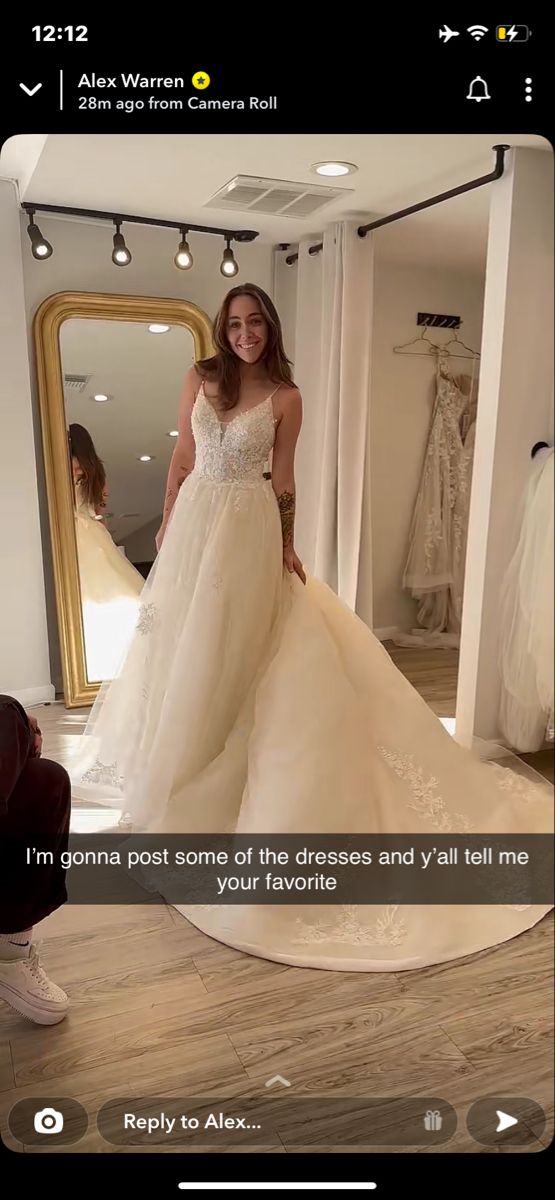 a woman standing in front of a mirror wearing a wedding dress