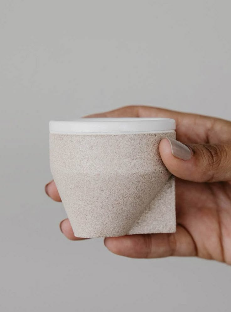 a person holding a cup in their left hand with a napkin on the other side