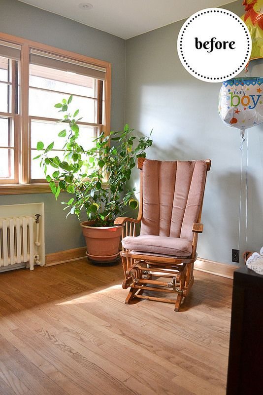 a rocking chair sitting in front of a window next to a wooden radiator