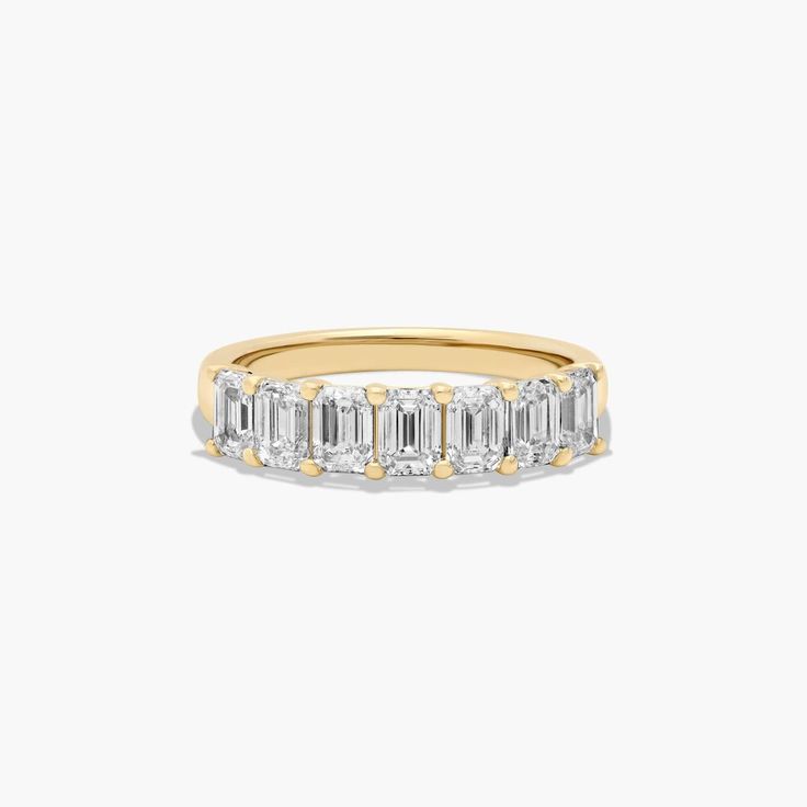 a yellow gold ring with three baguettes on the side and two rows of diamonds