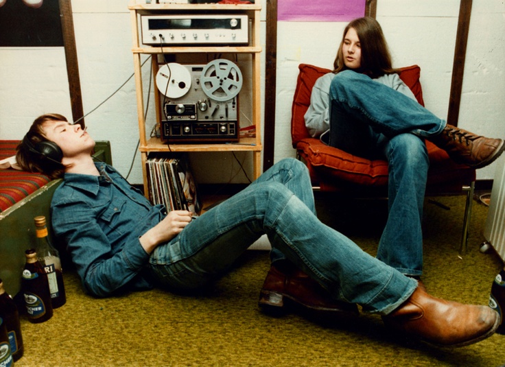 two people laying on the floor with headphones in their ears