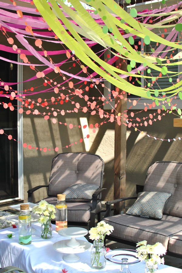 two lawn chairs under a canopy with streamers and confetti on the ceiling