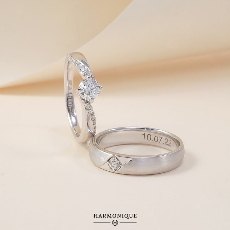 two white gold wedding rings with diamonds on the top and bottom, sitting side by side