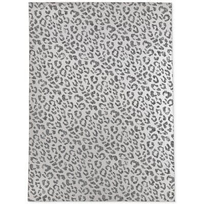 an animal print rug with grey and black spots on the top, in front of a white background