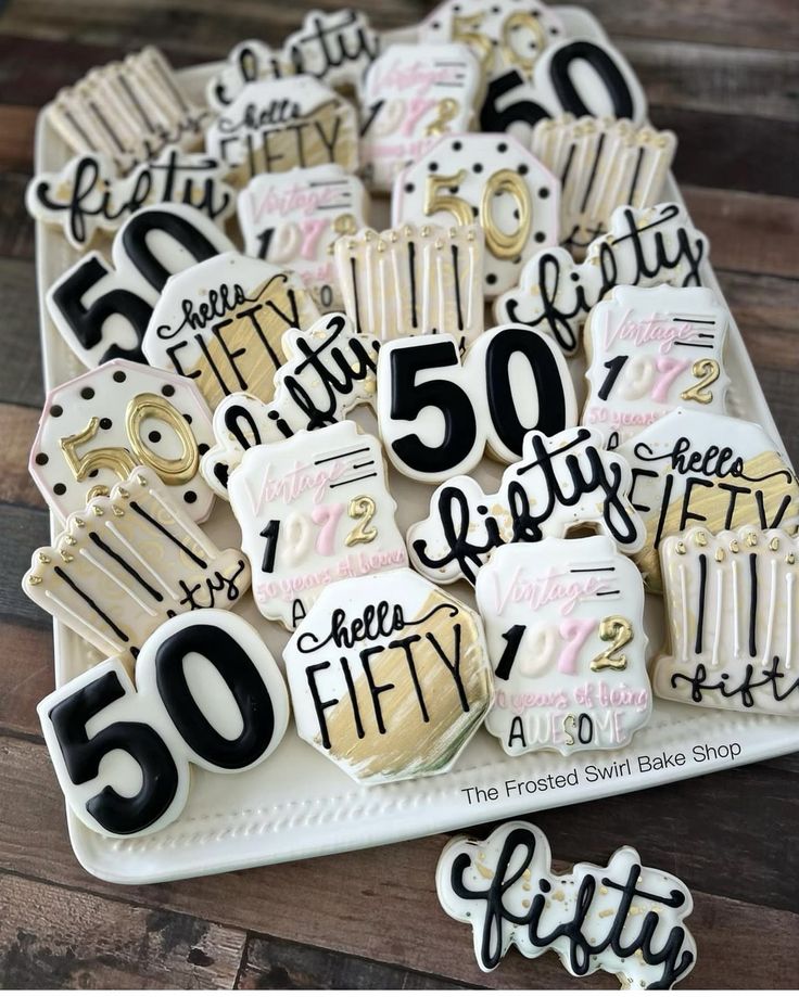 50th birthday cookies are on a plate with the numbers 50 and fifty written in black