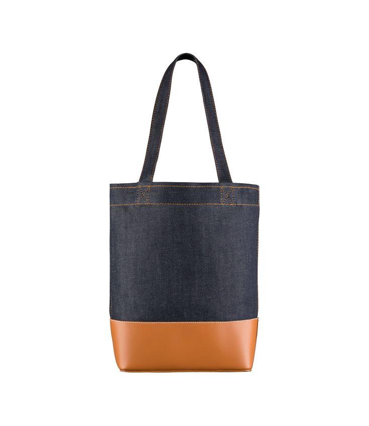 A.P.C. tote bag. - Tote bag in Japanese canvas.- Two large handles. May be carried on shoulder or by hand.- Wide band in smooth leather on bottom of bag.- Reinforced base.- Interior zip pocket.- Large A.P.C. logo in front.- Caramel topstitching on the denim. Faux Leather Bag, Exclusive Clothing, Japanese Denim, C Logo, Backpack Tote Bag, Japanese Fabric, Scarf Jewelry, Wide Bands, Tote Backpack