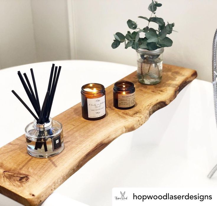 a wooden shelf holding candles and reeds in a bathroom