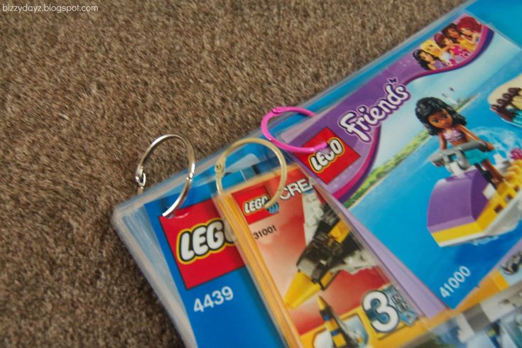 two lego keychains are laying on the carpet next to each other, one has an advertiser's name