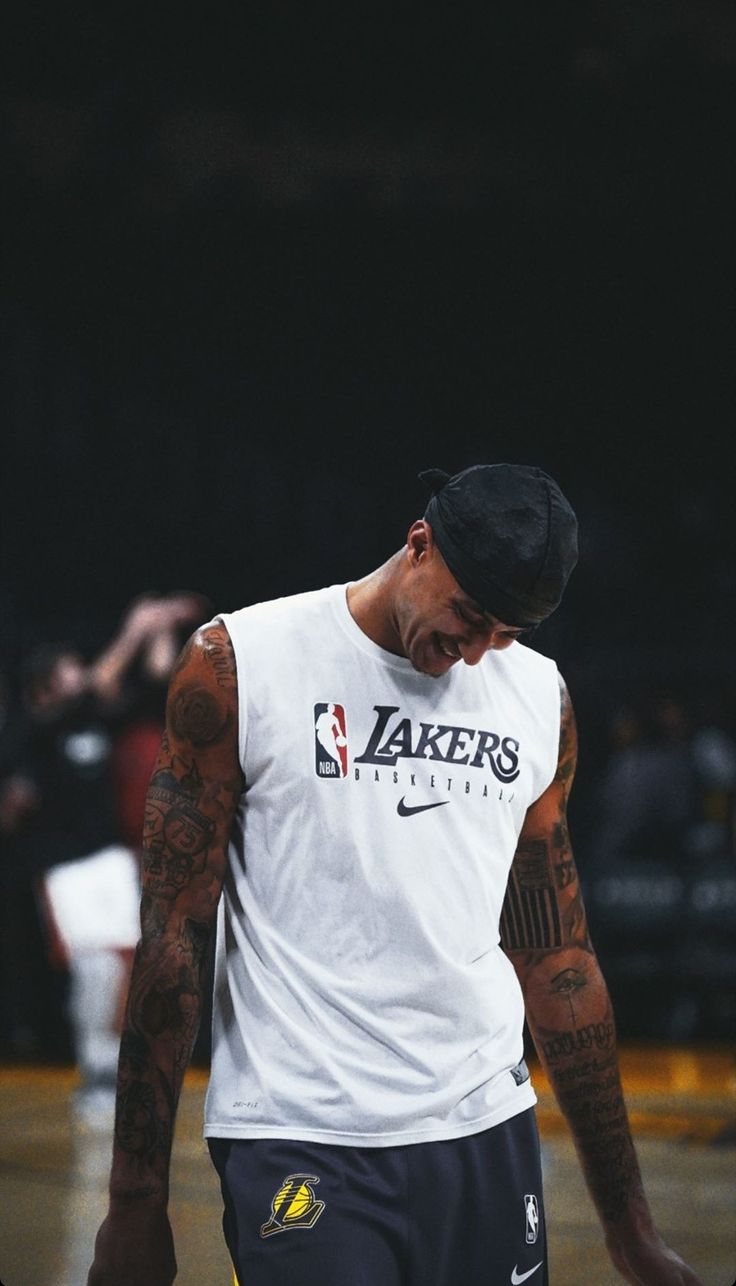 a man with tattoos on his arm and leg is holding a basketball in front of him