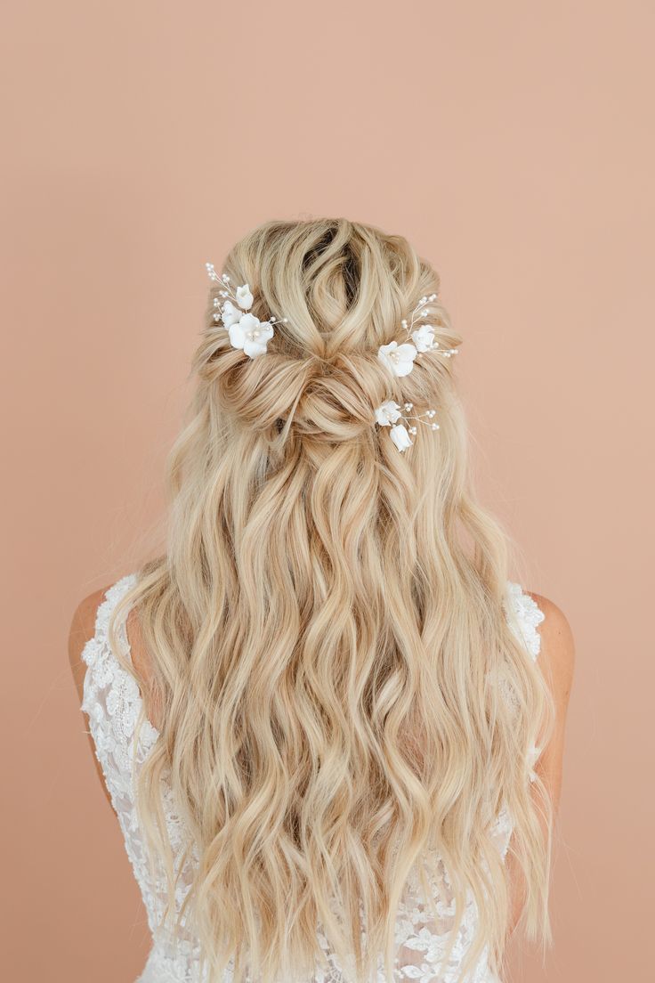 the back of a woman's head with long blonde hair and flowers in her hair