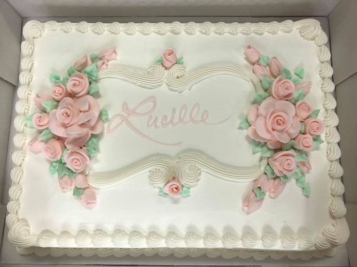 a large white cake with pink flowers on it's side and the word julia written in cursive writing