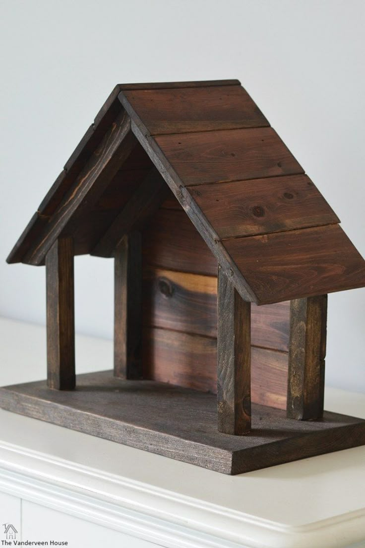 a wooden bird house sitting on top of a table