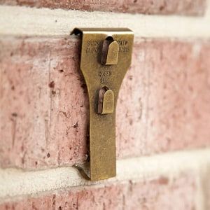 a brick wall with a metal hook on it