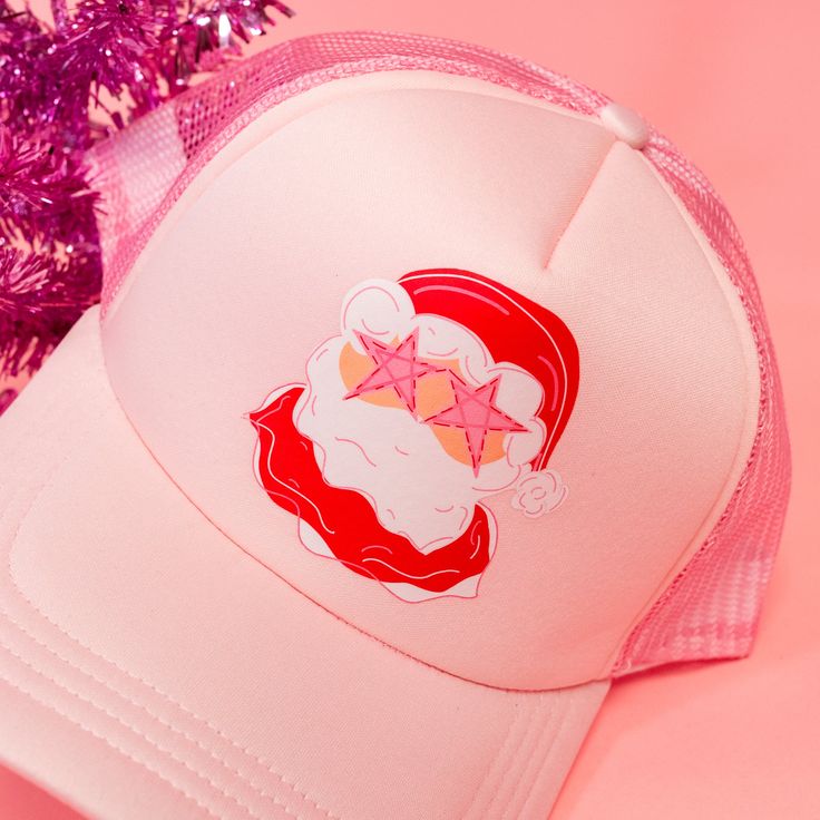 Star Eye Santa Trucker Hat! This pink hat features the cutest Santa glammed out with star eyes! This preppy Santa hat is perfect for the holiday season! The best gift for a bestie who loves trucker hats and Santa! This trucker hat is the best winter accessory! Complete your cozy look with this hat! Treat yourself or your bestie to this adorable hat! A unique accessory to make any outfit stand out! Spread the holiday cheer with this pink hat! This funky santa is just what you need for holidays! T Pink Novelty Winter Hats, Pink Trucker Hat As Gift, Pink Novelty Mini Snapback Hat, Pink Baseball Cap Mini Hats For Party, Pink Mini Baseball Cap For Parties, Pink Trucker Baseball Cap For Gift, Pink Trucker Snapback Hat As Gift, Pink Trucker Baseball Cap As A Gift, Pink Snapback Hat As Gift