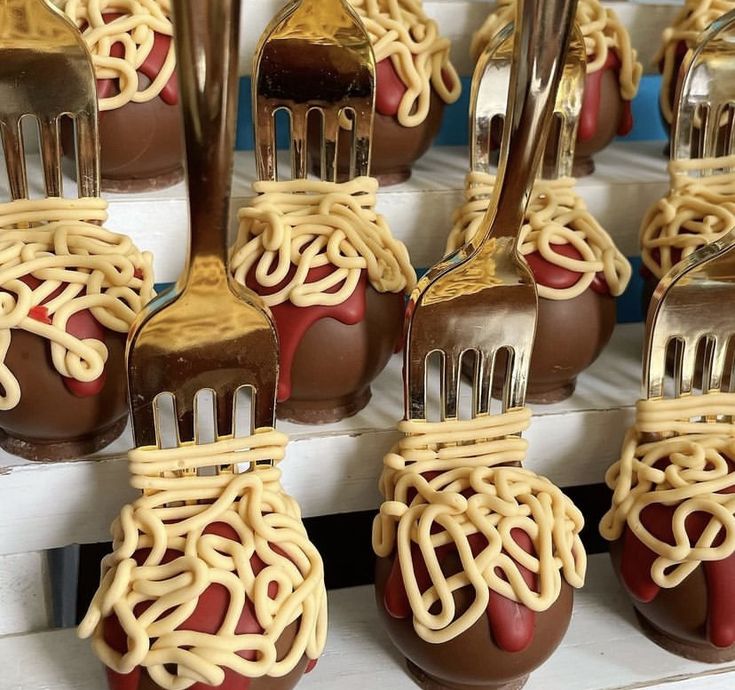 chocolate covered forks with noodles and sauce on them