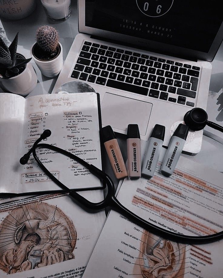 an open laptop computer sitting on top of a desk next to medical supplies and other items