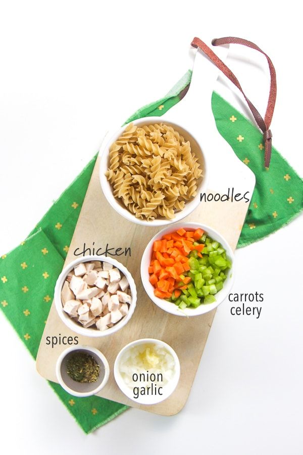 an assortment of ingredients in small bowls on a wooden cutting board with a green cloth