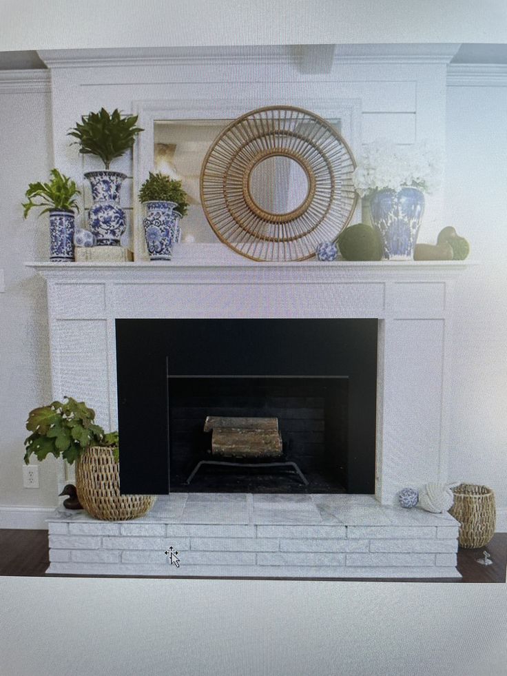 a white fireplace with blue and white vases on it