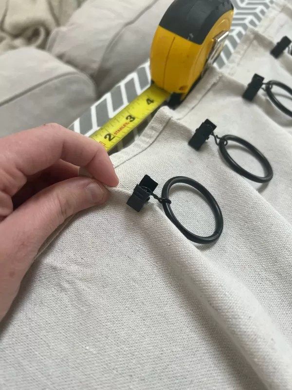 a person is measuring the length of their bed with tape measure and scissors on it