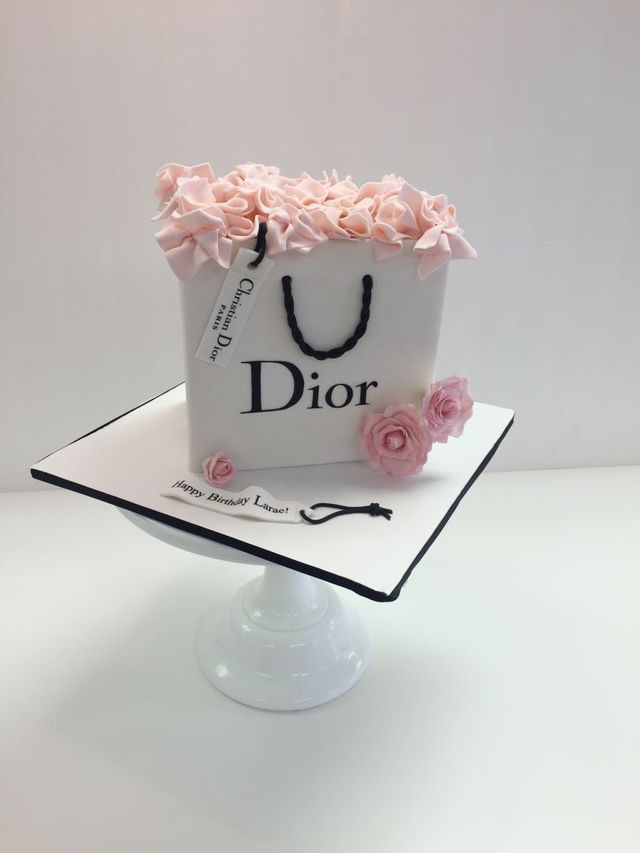 a bag cake with pink flowers on top