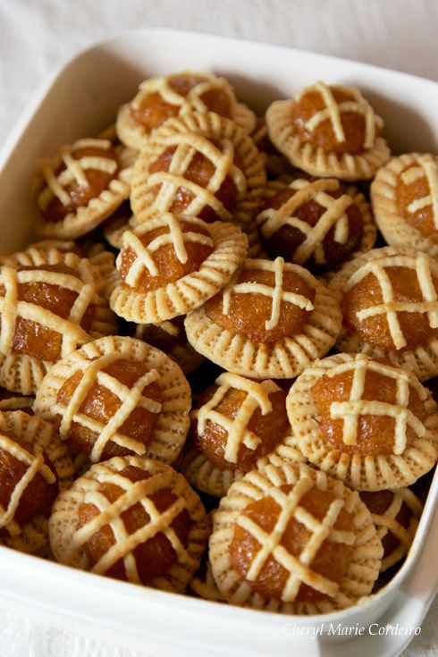 a white dish filled with mini pies on top of a cloth covered tablecloth