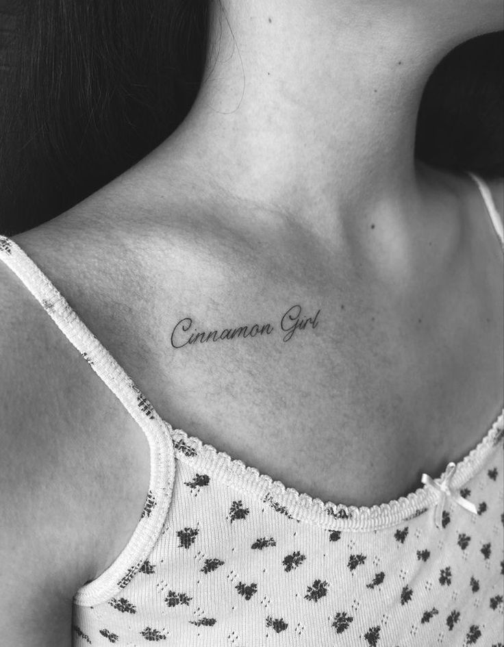 a woman's chest with the words camera girl tattooed on her left side ribcage