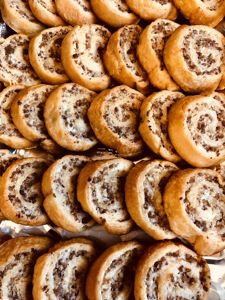 there are many cinnamon rolls on the tray