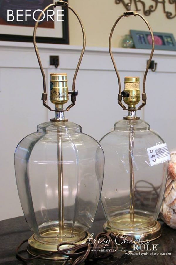 two glass lamps sitting on top of a wooden table