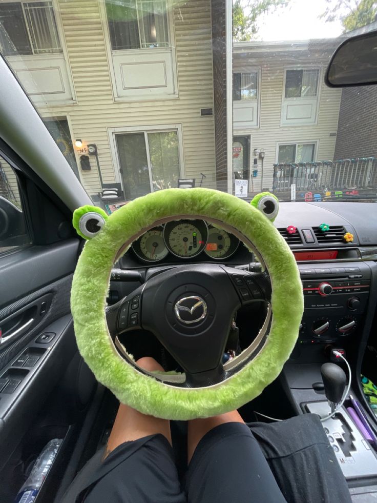 someone is sitting in the driver's seat of a car with their feet on the steering wheel