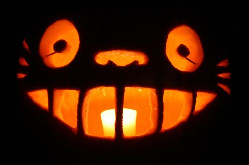 a carved pumpkin with an evil face on it's face, lit up in the dark