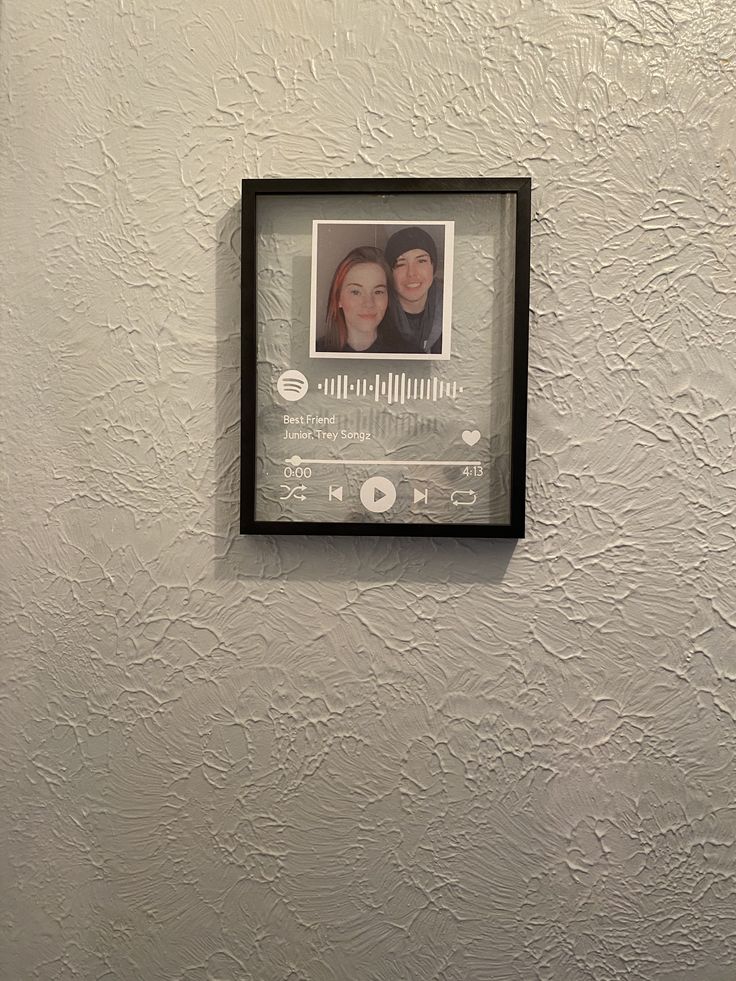 a photo hanging on the wall next to a toilet in a room with white walls