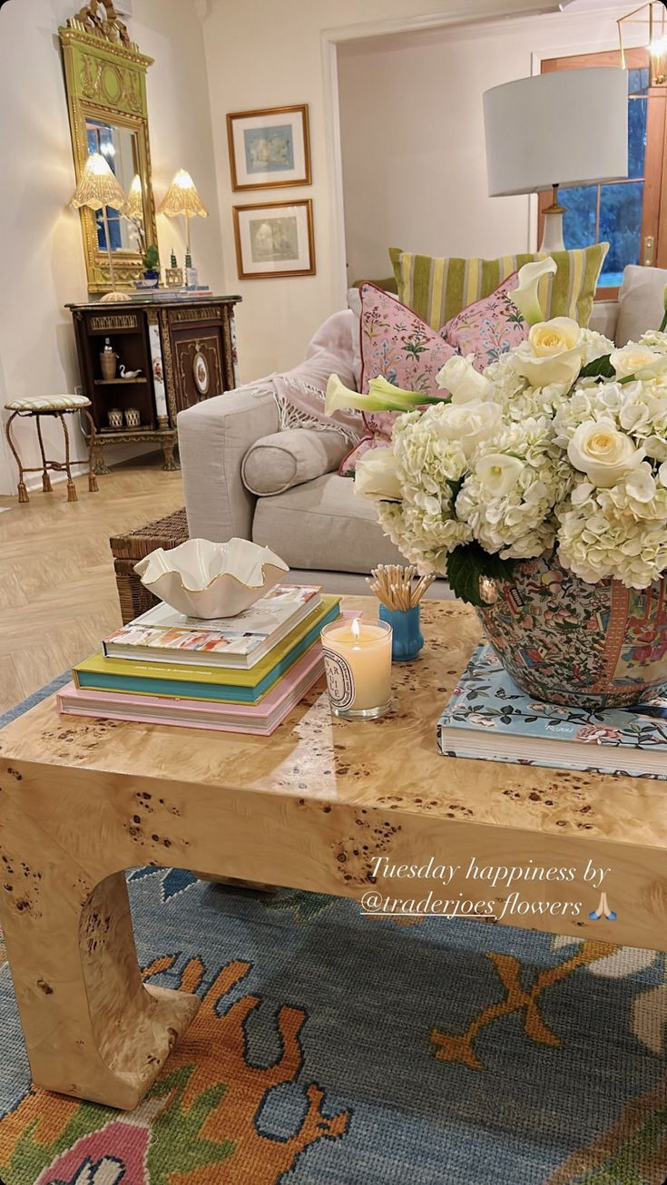 a living room filled with furniture and flowers on top of a coffee table in front of a couch