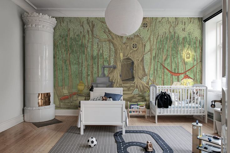 a child's room with a mural on the wall and a baby crib