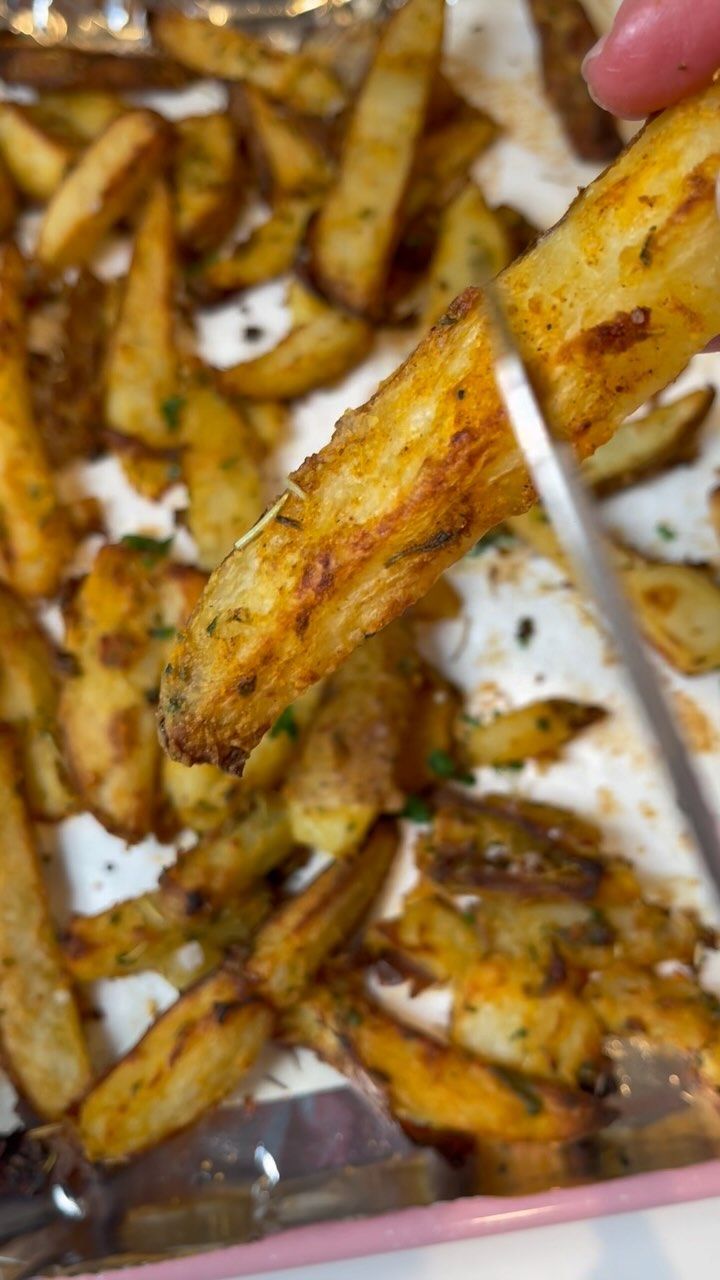 someone is cutting up some french fries with a knife