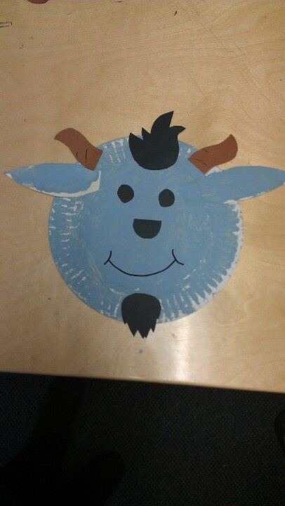 a child's paper plate with a blue cow on it sitting on top of a wooden table