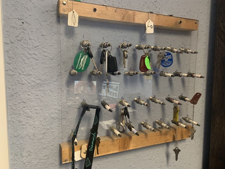 a wall mounted display with lots of keys and other items hanging on it's sides