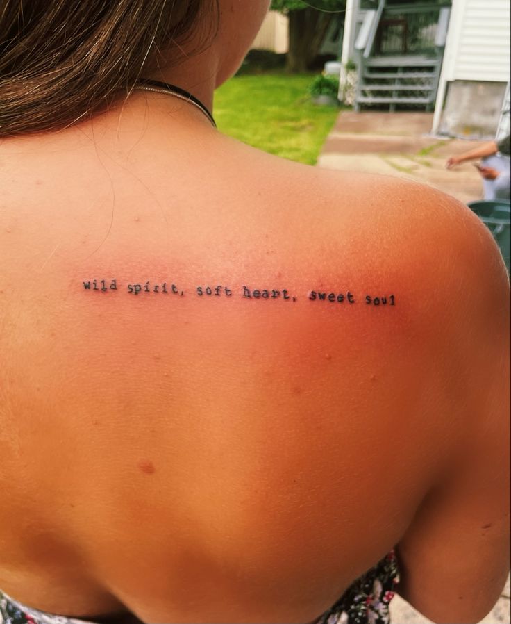 a woman with a tattoo on her back saying wild spirit, soft heart, sweet soul