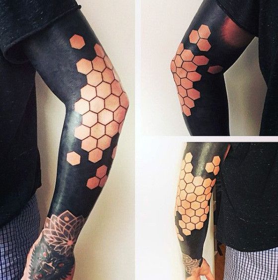 the arm is covered in honeycombs and tattoos