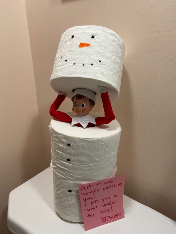 an elf is sitting on top of a stack of toilet paper