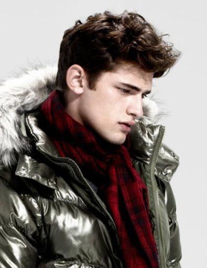 a young man wearing a shiny coat and scarf