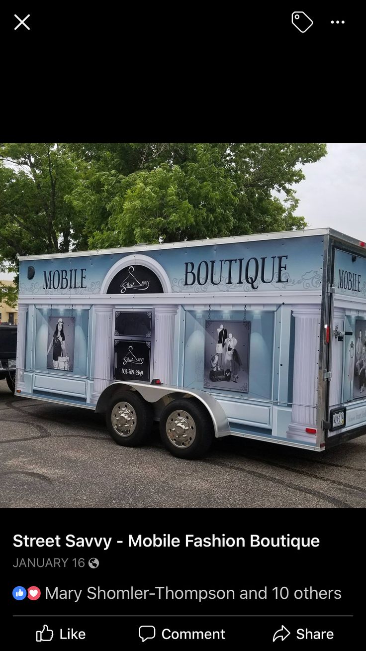 a mobile fashion boutique truck parked in a parking lot next to some trees and bushes